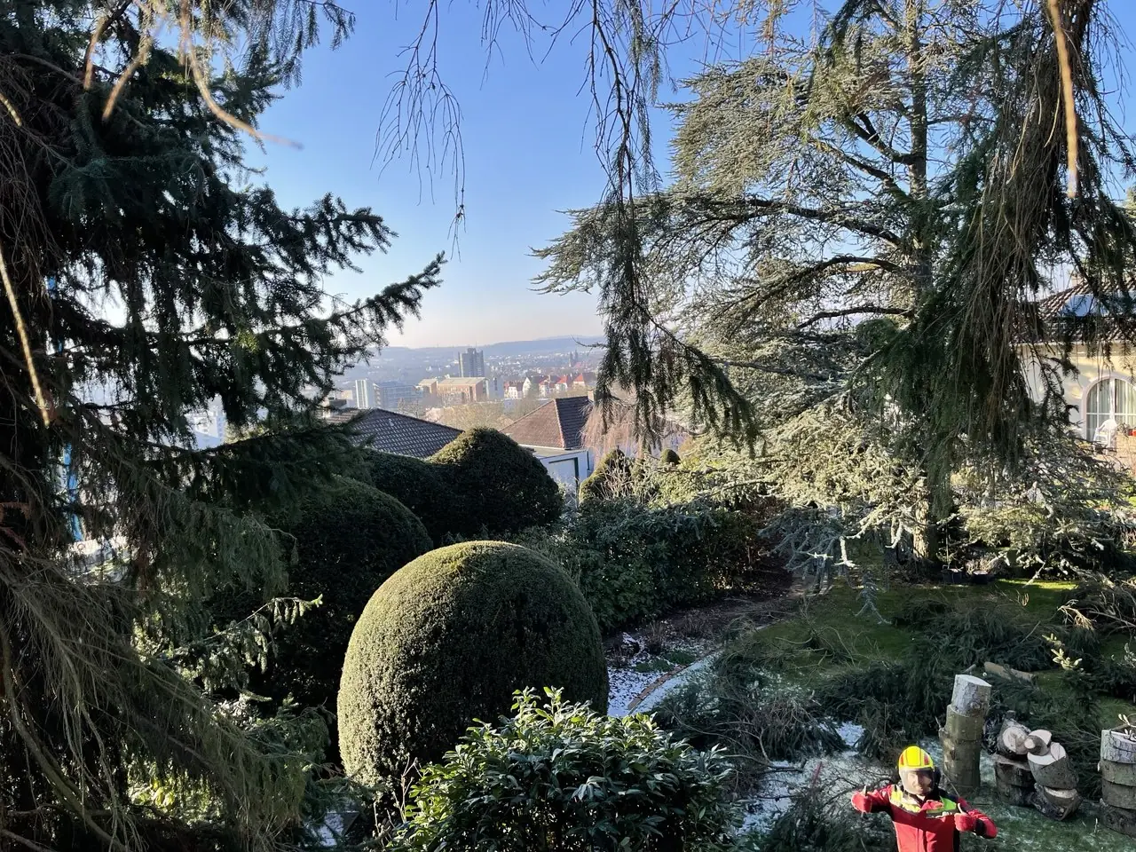 Garten mit Kugelbäumen und Blick ins Tal
